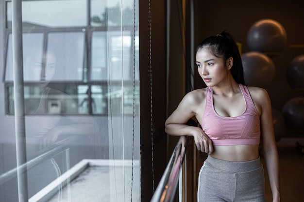 woman-standing-relaxed-hands-placed-steel-rail-gym_1150-16538