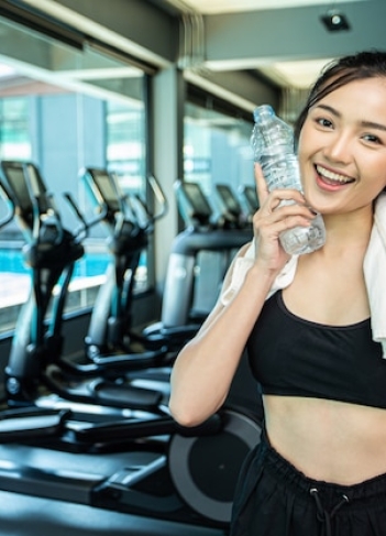 woman-standing-relaxing-after-exercising-holding-bottle-water-touch-face_1150-16444